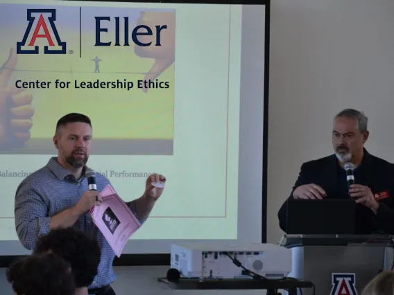 Two professors in front of a screen